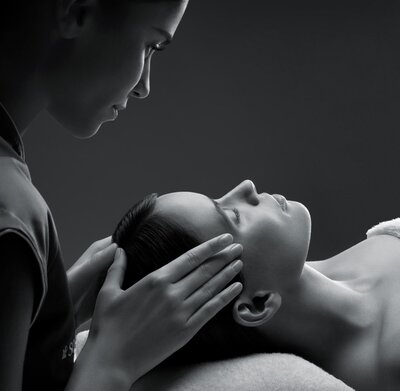 A woman is having her scalp and face massaged
