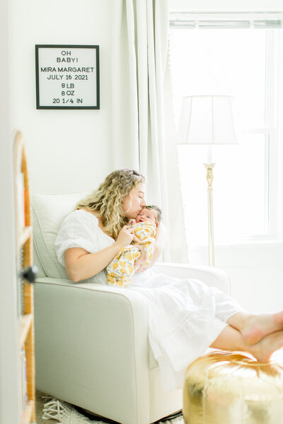 Mother holding newborn giving kisses in Green Bay