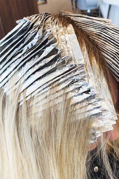 Blonde hair undergoing foil highlights treatment at Blake & Kwan Cronulla, highlighting professional hair coloUring techniques.