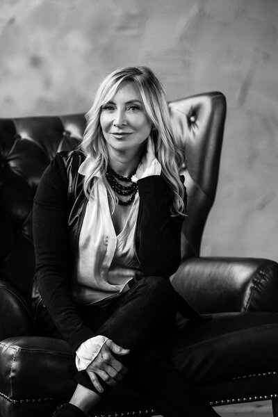 black and white photo of a woman sitting on a chair