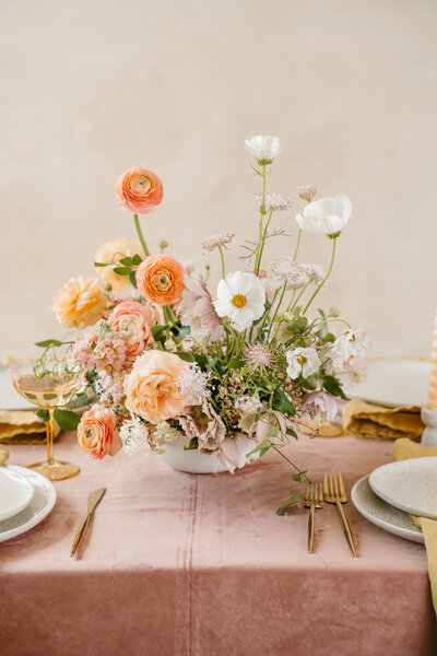 A large, colorful bouquet by Anthousai lays on a flat surface
