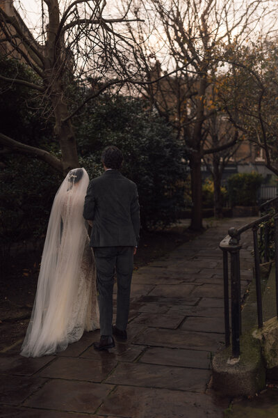 Wedding photographer captures couple taking a stroll hand in hand at their french chateau wedding.