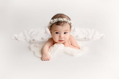 3 month baby looking at camera on white backdrop