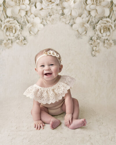 Smiling baby portrait in a cream flower background