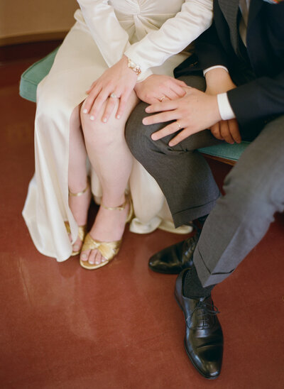Bride adjusting shoes while preparing for Marin courthouse wedding ceremony.
