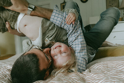 dad holding son upside down during family photos captured by NYC family photographer Elsie Goodman