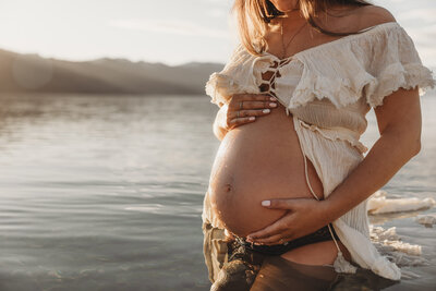a pregnant belly in the water during a wanaka maternity photoshoot