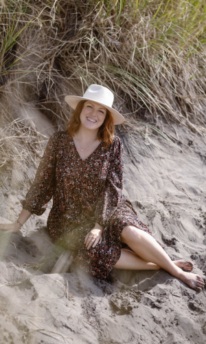 young woman smiling in front of a bridge