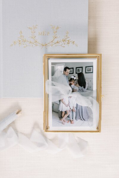 Light blue ribbon, photographs in a gold box, and a light blue heirloom album