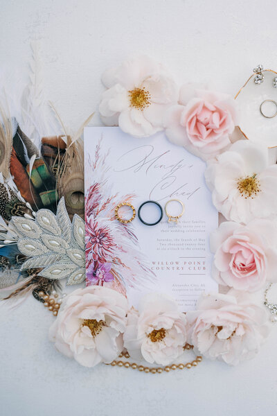 rings laying on piece of paper with florals and leaves surrounding it 