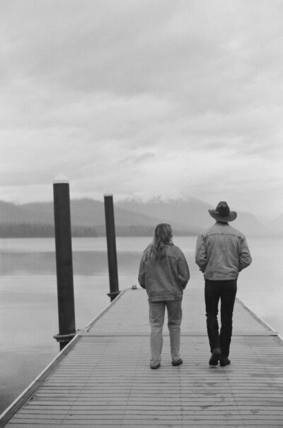 couple walking on dock at lake mcdonald in glacier national park