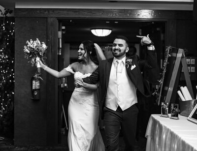 Joyful couple enters  their Concourse at Union Station wedding reception