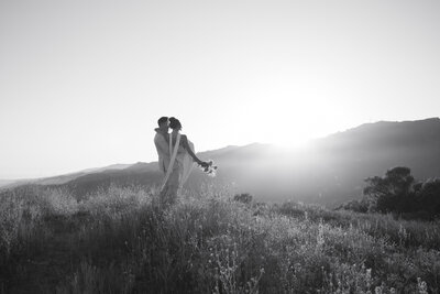 Robby holding emily walking through the Topanga canyon as the sun sets over the mountains