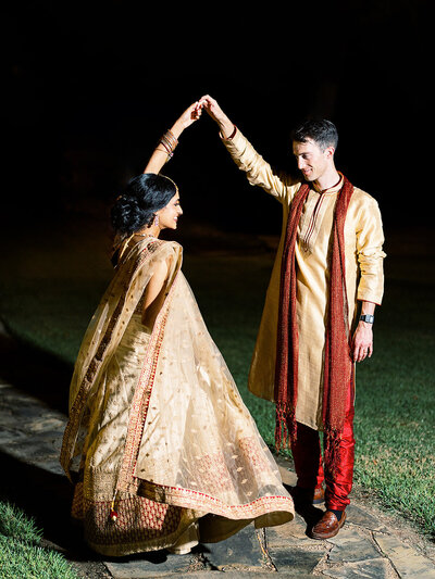 Bride and groom in Indian wedding attire dancing