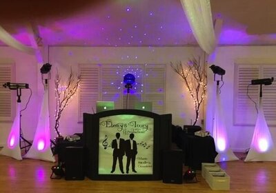 Event picture showing brilliant fuchsias and light purple washes with DJ Facade and sound system
