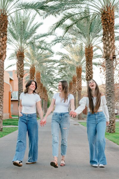 3 senior girlfriends walking down palm walk at ASU