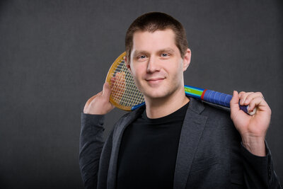 Headshot of a man holding a tennis racket