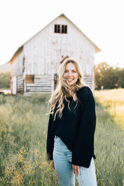 Adventure wedding photographer smiling in a field in colorado