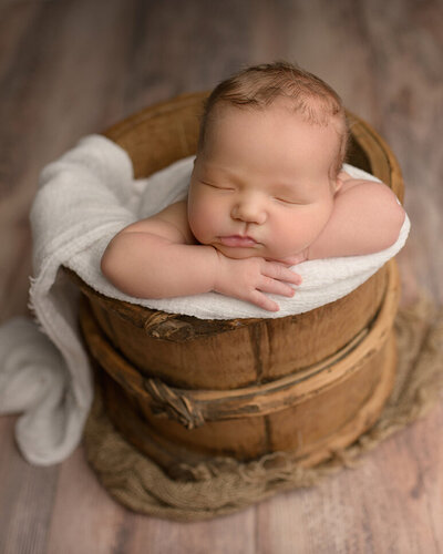 baby posed in a bucket during boston newborn photography session