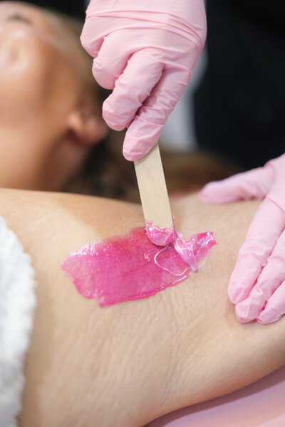 Close up of Macyla Hopper applying wax during a body wax service in her studio in Hartselle, Alabama