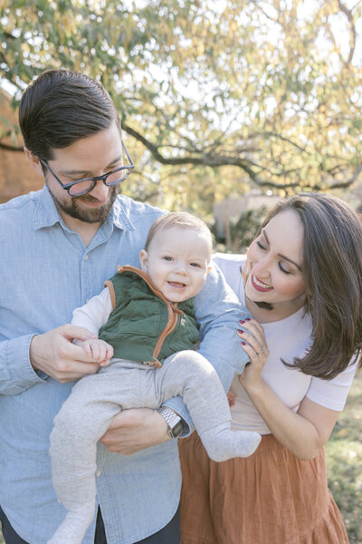 Mom and dad holding their baby boy and smiling at him in Alexandria, Virginia