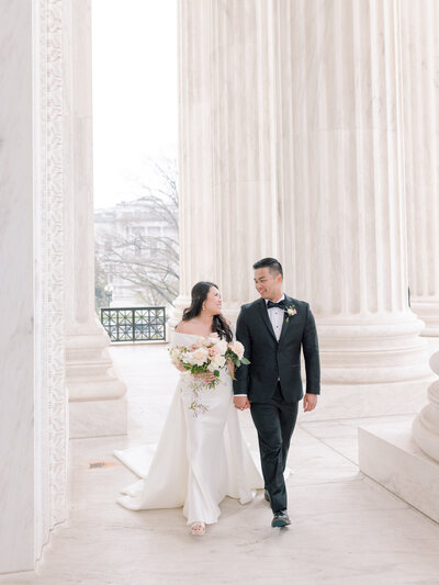 Newlywed couple in wedding dress and tux walking hand in hand at the US Supreme Court