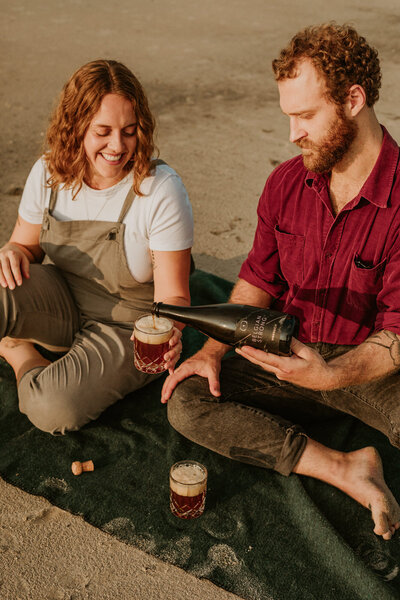 Couple enjoying a beer at the beach