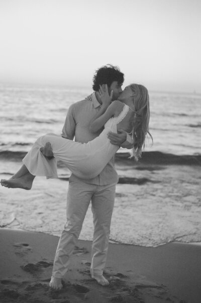 couple standing on rocks near waterfall