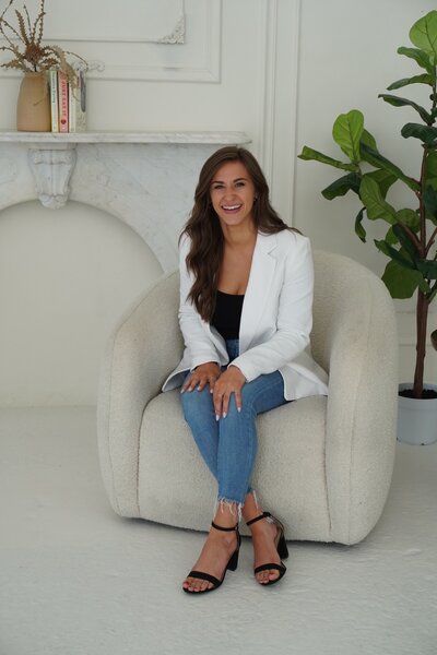 Registered dietitian Jackie Jozefiak sitting on a chair laughing.