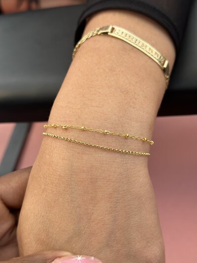 Stack of gold permanent bracelets from Jazzy's Glam Bar in Tampa, FL