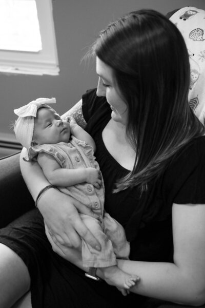 Photo of Mom looking down at baby while holding her | Maine Newborn Photography