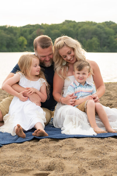 A family sitting closely together at the beach.