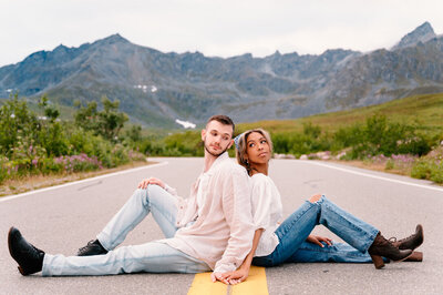 engaged couple sitting in the street holding hands