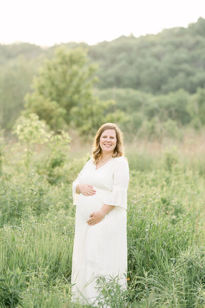 Pregnant mother wears white dress from Julie Brock Photography during Louisville KY outdoor maternity photo shoot in Louisville KY.