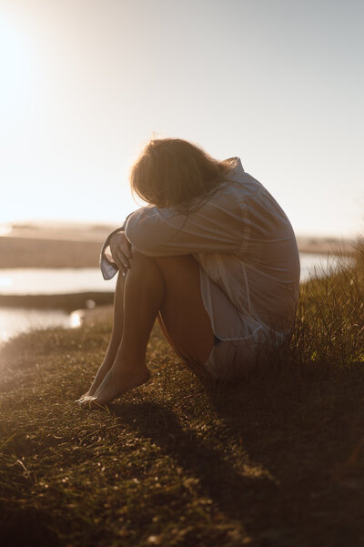 Intimate portrait of a woman sitting by the ocean