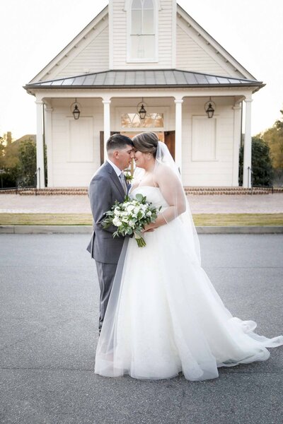 Newly married couple poses in front of South Carolina white chapel