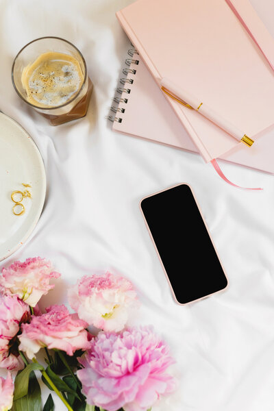 Flat lay with notebook, phone, and coffee for a style clarity call.