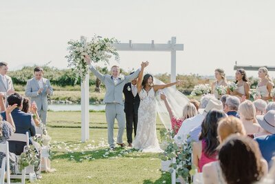 bride and groom happy after ceremony with floral arch all white flowers at Cavaignac
