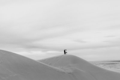 a couple getting married in the desert on a sand dune