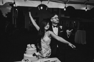 black and white image of bride and groom with wedding cake
