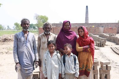 Enslaved family standing in front of the kiln.