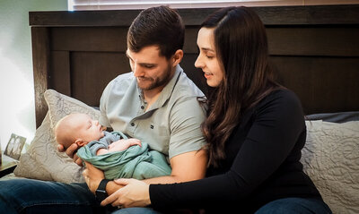 Mother and Father holding newborn baby at home Cherry Blossom Doula Photography