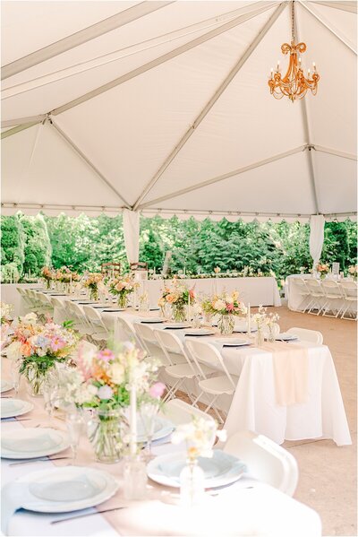 Wedding reception photos inside white tent decorated with wildflowers 
