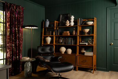 a green sofa and desk in a bedroom