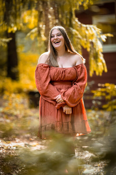 natural light senior portrait of a senior laughing in a park surrounding by trees near Sewickley PA. Captured by Michael Fricke Photography, a senior portrait photographer.