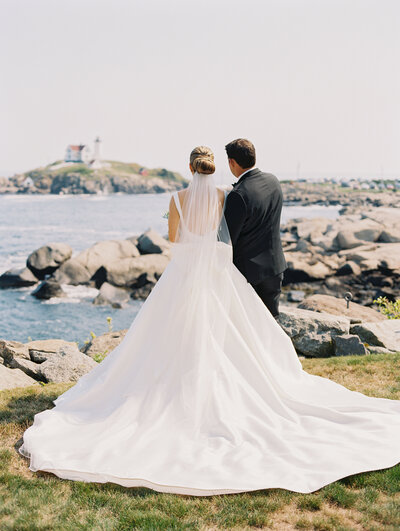 Couple walking on the beach in New England after their wedding ceremony