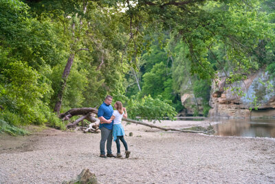 Adventurous couple  dancing near creek shore