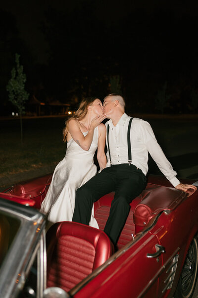 Flash photo of bride and groom kissing in getaway car at Nashville wedding
