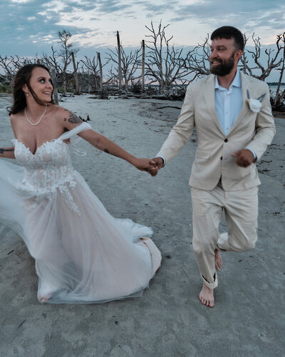 Couple running on the beach towards the camera