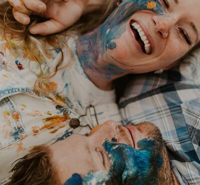 couple smiling and laughing covered in paint